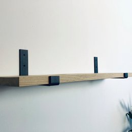 Wooden book stand with black metal supports, suitable for holding books or other items.
