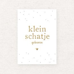 A white card with gold foil text that reads "klein schatie geboren" (Dutch for "little treasure born"). The card has a simple, minimalist design with small gold dots or stars in the background.