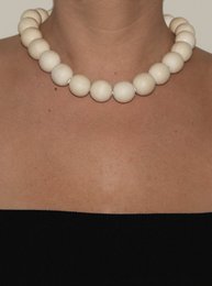 Cream-colored beaded necklace with round, smooth beads.