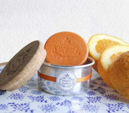 Orange-scented soap in a jewelry box-style container made of cork and aluminum.