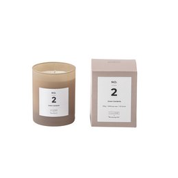 A tall, round green gardenia-scented candle in a beige container.