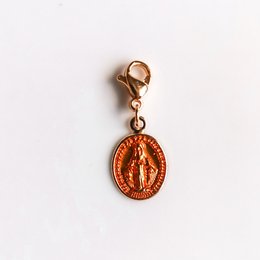 Oval-shaped gold-colored pendant with a religious image of the Miraculous Medal.