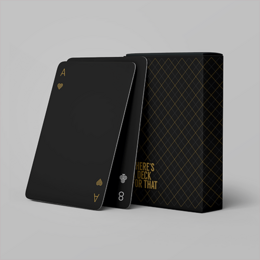 A black card game box with a gold logo and a black card with a white star design on a red background.