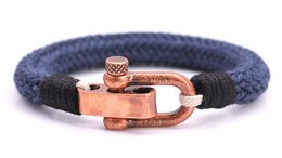 Nautical-inspired woven bracelet in a copper blue color, featuring a rose gold-plated anchor clasp. Suitable for medium to large wrist sizes.