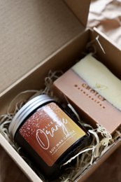 Cozy orange-scented candle in a gift box, perfect for creating a hygge atmosphere.