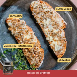 A vegan roasted pork spread made with organic ingredients. The product has a black and gold label with the brand name "Goldblatt" and the product name "Pork Taste (vegan roasted pork spread)". The spread is in a glass jar with a black lid.