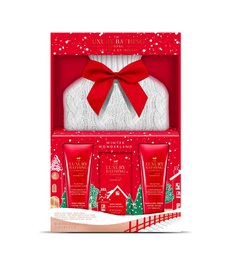 A festive gift set featuring a Wild Fig & Cranberry scent, including a candle, hand cream, and bath fizzer in a red and white gift box with a bow.