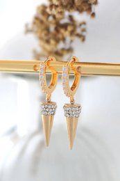 Aretes tipo argolla con forma de cono y punta con circonita cúbica de 24 quilates