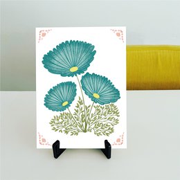 Cool flise med petroleumsfarvede blomster og lyserøde detaljer