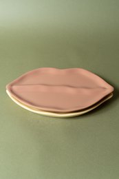 Decorative ceramic lips-shaped jewelry trays in various shades of pink and gray.
