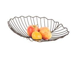  Decorative metal fruit bowl with a leaf-shaped design, holding several round yellow fruits.