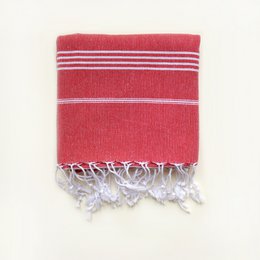 Red and white striped hammam towel with the name "LAURA" embroidered on it. The towel has tassels on the ends.