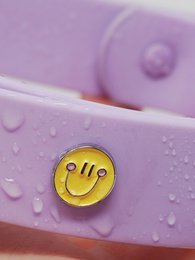 Colorful dog collar with a happy face design, available in blue, pink, yellow, and purple.