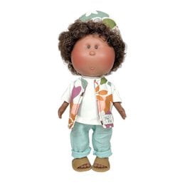 A plush baby doll with curly brown hair, wearing a white shirt, mint green pants, and brown sandals. The doll has a friendly, smiling expression.