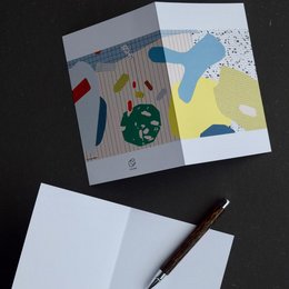 Colorful abstract note cards with geometric shapes and patterns. The cards feature a vibrant mix of yellow, blue, and green shapes against a white background with a speckled pattern.