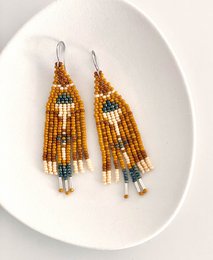 Beaded statement earrings in shades of orange, yellow, and brown with a tassel design.