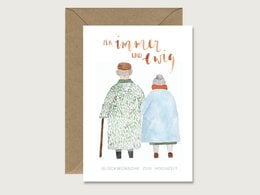 Greeting card with illustration of a married couple in winter attire, text reads "the happiest of days"