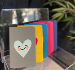  Colorful pocket notebooks with a smiling heart design, available in various colors including gray, yellow, blue, black, marine, fuschia, and red.