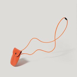 Orange leather pouch with adjustable strap for kids.