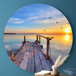 Large circular wall art depicting a wooden dock at sunset with birds flying in the sky. The image shows a peaceful, serene landscape with warm colors and a tranquil atmosphere.