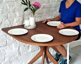  A round, wooden dining table with a racetrack design, suitable for 4 people. Available in natural ashwood, oak stained ashwood, walnut stained ash, white stained ash, and black stained ash finishes.