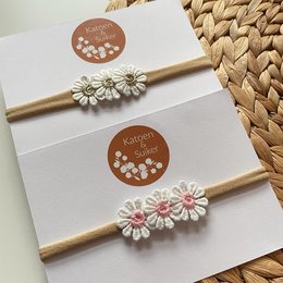 Newborn headband with pink daisy flowers, made of soft, flexible material. Suitable for infants and young children.