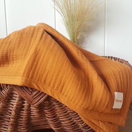 Soft, organic 4-layer muslin baby blanket in a warm, earthy brown color. Measures 115 x 85 cm.