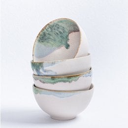 A round, ceramic mixing bowl with a mottled green and pink glaze finish.