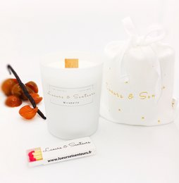 A tall, round white candle with a cotton wick. The candle is scented, with notes of citrus and vanilla.