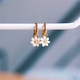 Stainless steel hoop earrings with a delicate 'daisy flower' design in a creme/gold color. The earrings feature a cluster of small white pearls hanging from the hoops.