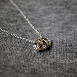 A sterling silver necklace with three interlocking rings, representing unity and connection.