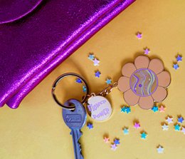 Colorful flower-shaped keyring with charms and glitter accents, suitable for accessorizing and adding a playful touch to keys.