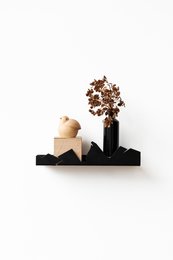  Black mountain-shaped wall shelf, minimalist design, modern home decor, holds decorative items and plants.