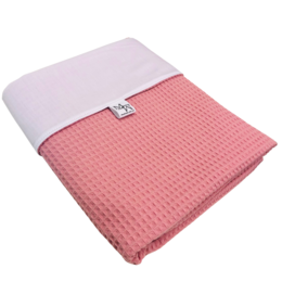 A soft, cozy waffle-textured baby blanket in a combination of white and coral pink colors, available in different sizes.