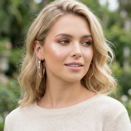  Rose gold hoop earrings with a unique curved design and a small crystal accent.