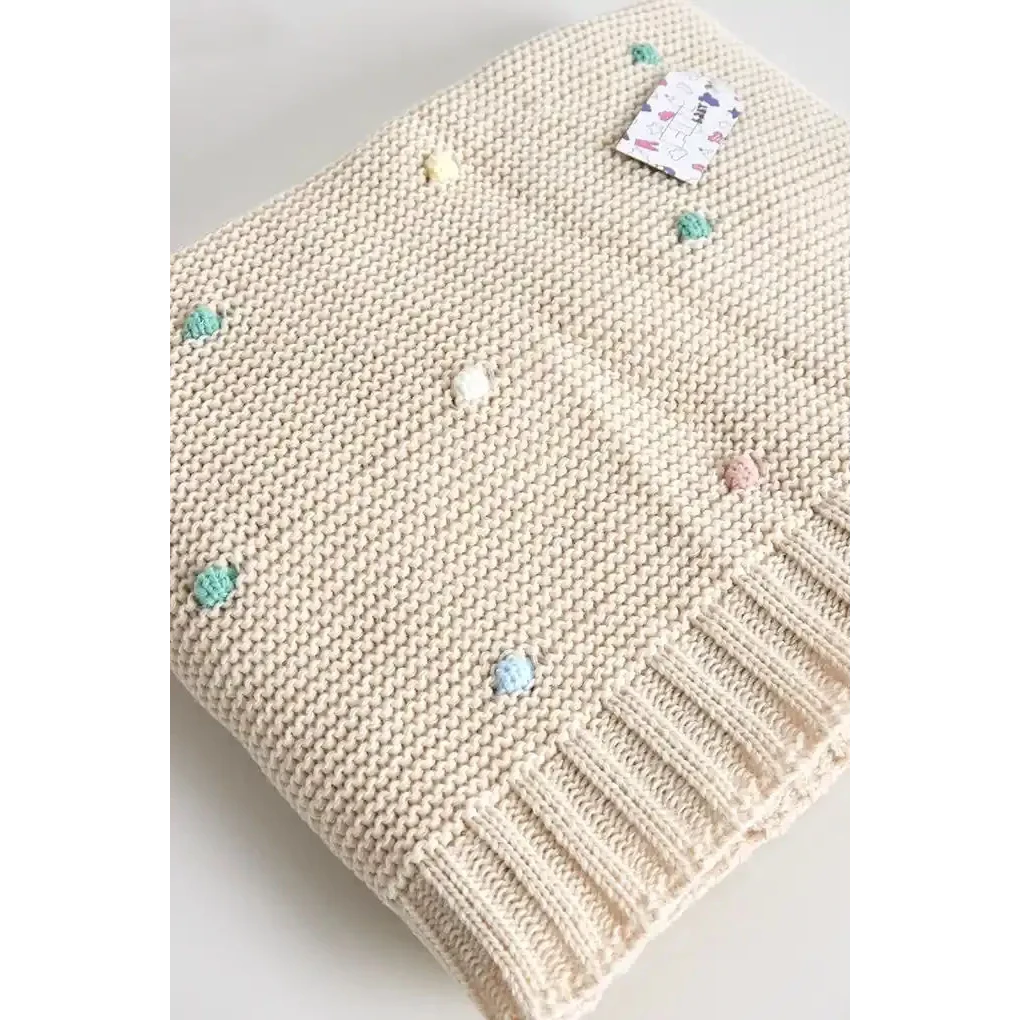 Baby striktæppe med farverige pomponer