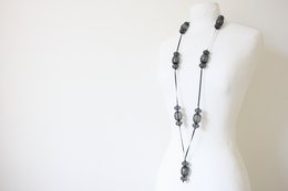 Long black necklace with oval-shaped charms