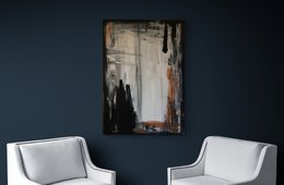 Abstract wall art with a mix of black, white, and orange brushstrokes on a dark background.