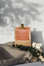 Packet of fondants n°41 with scents of hazelnut, pepper, cedar, and tonka. A decorative scented candle in a square glass container.