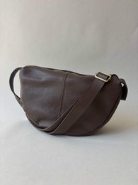 # Product Description

Brown leather shoulder bag, curved crescent shape, soft slouchy style, adjustable strap, minimalist design.