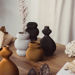 Decorative vase with a round, ribbed shape in a warm, earthy tone.