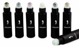 Gemstone rollers with natural perfume, skin care tools, round glass bottles with roller applicators, various colors including clear, green, and pink.