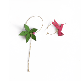 Mismatched hoop earrings with pink hummingbird and green leaf charms, nature-inspired design.