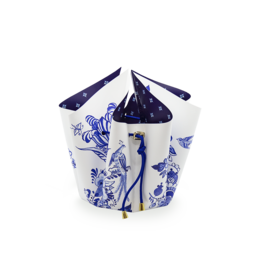 A delft blue and white ceramic folding vase with a floral arrangement of blue and white flowers.