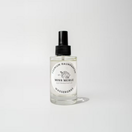 Room spray with ginger and lemongrass scent, in a clear glass bottle with a black spray top.