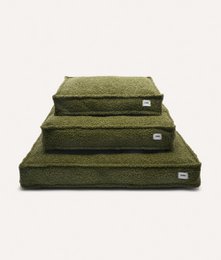 Green sheepskin dog bed, available in sizes M, L, and XL. Soft, plush material provides comfort and warmth for your furry friend.