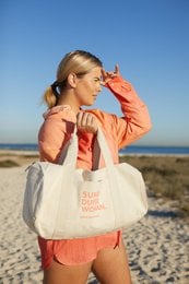 Large, durable canvas tote bag in off-white color with "Super Duper Woman" text printed in bold lettering. Suitable for weekend getaways, beach trips, or everyday use.