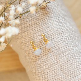  Elegant moonstone ball stud earrings with a delicate gold-tone finish.
