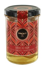 A round, tall glass jar containing a golden-colored liquid, likely a rum-based dessert or baked good. The jar has a red and gold label with a floral pattern, indicating it is a specialty or gourmet product.