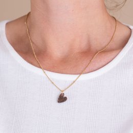 Gold-toned necklace with a heart-shaped pendant featuring red rhinestones.